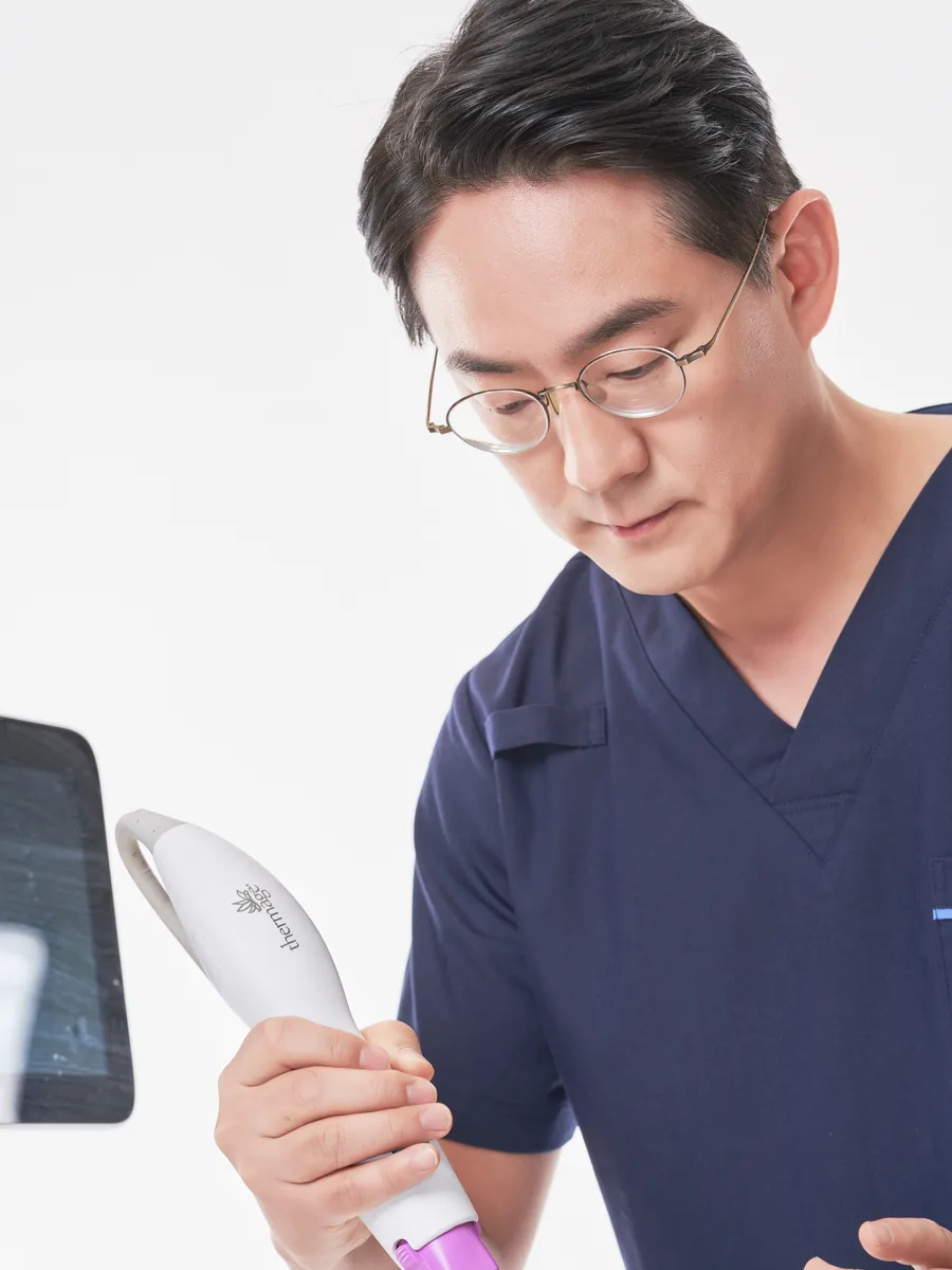 Dr. Choi holding a treatment handpiece at Wells Clinic